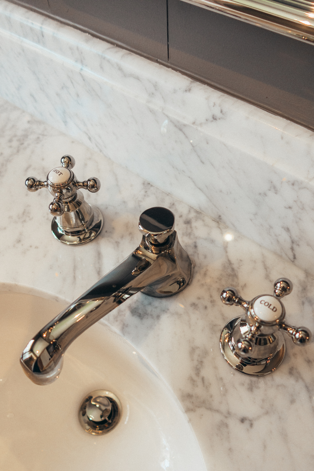 timeless bathroom, cottage core, brown bathroom, bathroom remodel ideas, Sophisticated bathroom retreat with timeless finishes and lighting, interior designer houston, interior design, Elegant Carrara marble bathroom countertop with polished nickel fixtures
